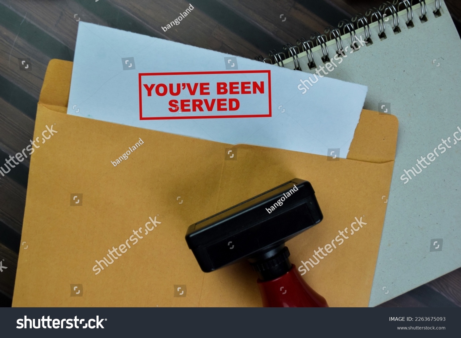 Concept of Red Handle Rubber Stamper and You've been Served text above from brown envelope isolated on on Wooden Table. #2263675093