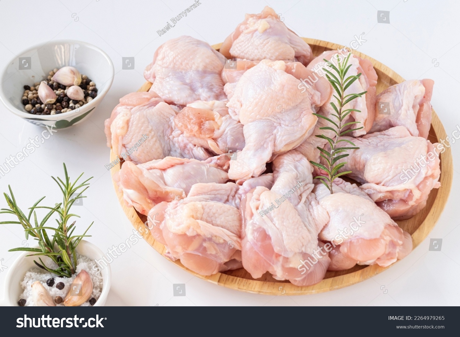 Fresh chicken fillet in wooden tray, salt, black pepper, white pepper and rosemary on white background. #2264979265