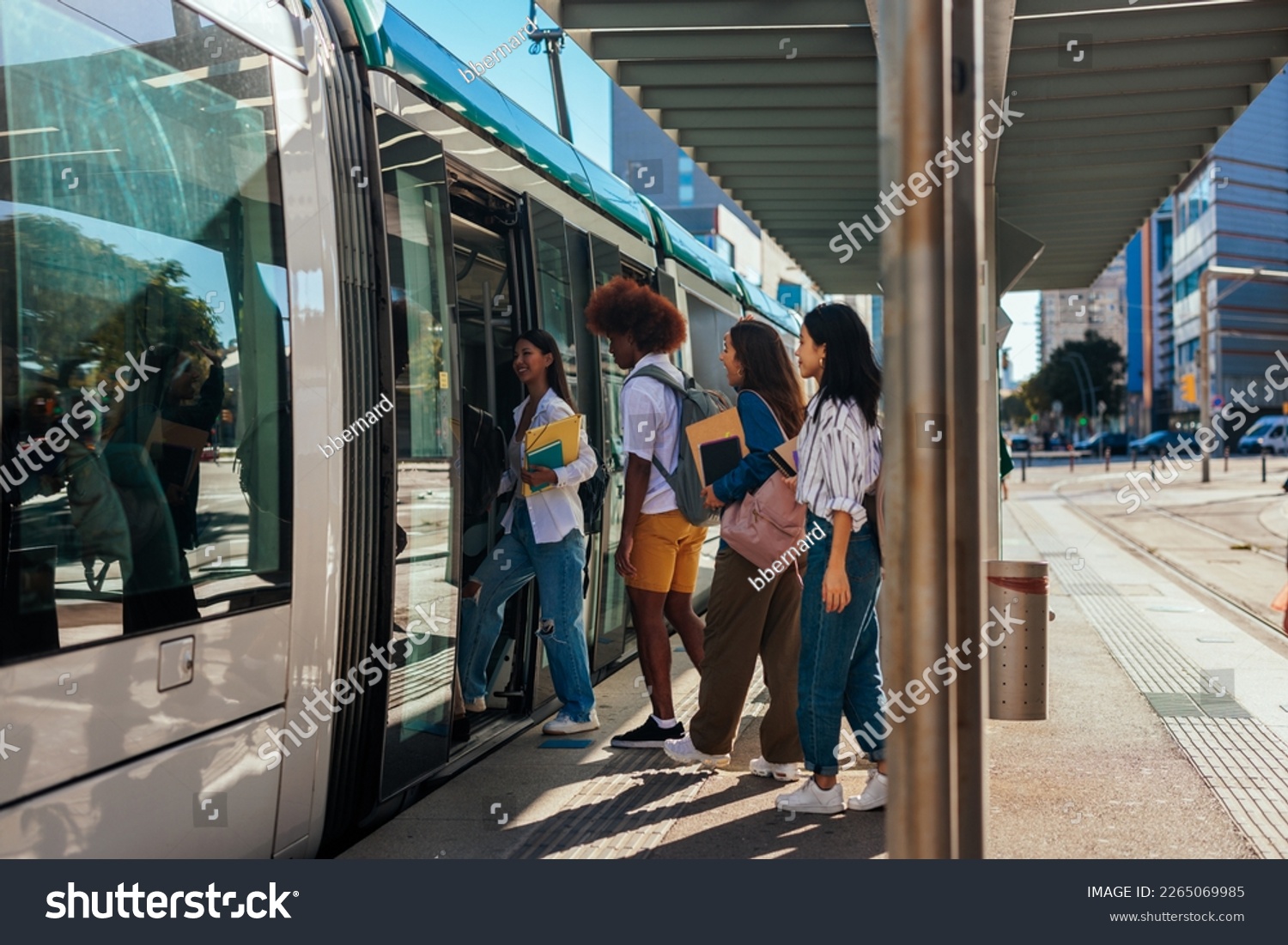 A group of university students going home after classes at school are entering the public transportation train. #2265069985