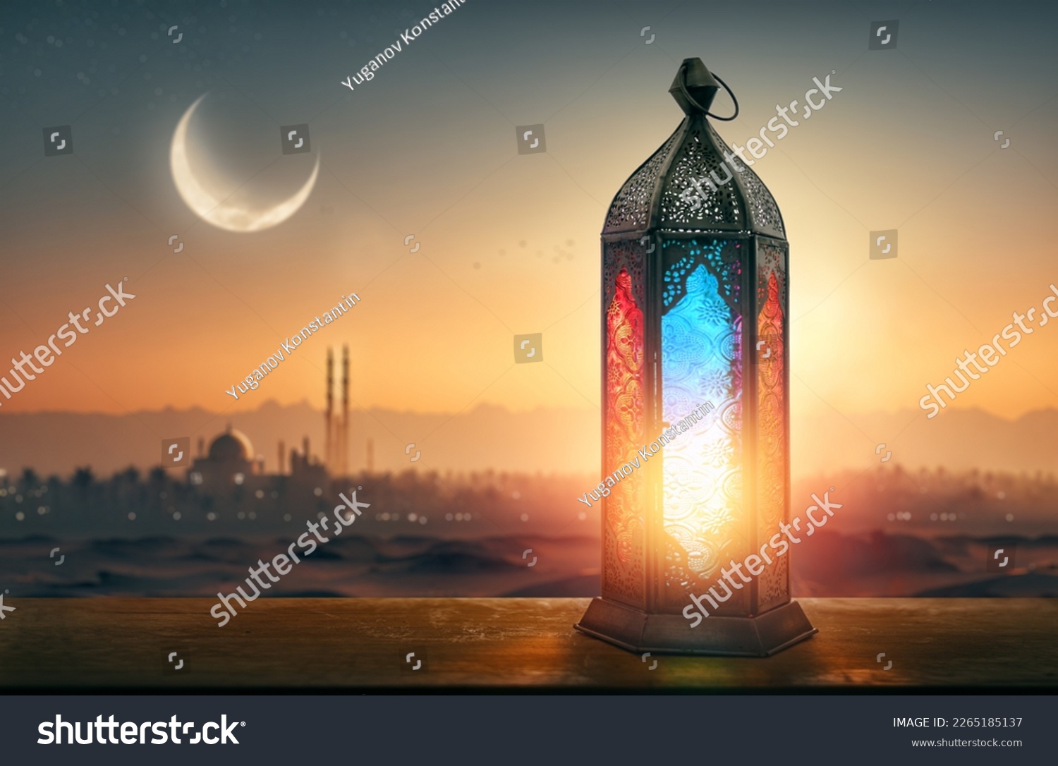 Ornamental Arabic lantern with burning candle glowing at night mosque background. Festive greeting card, invitation for Muslim holy month Ramadan Kareem. #2265185137