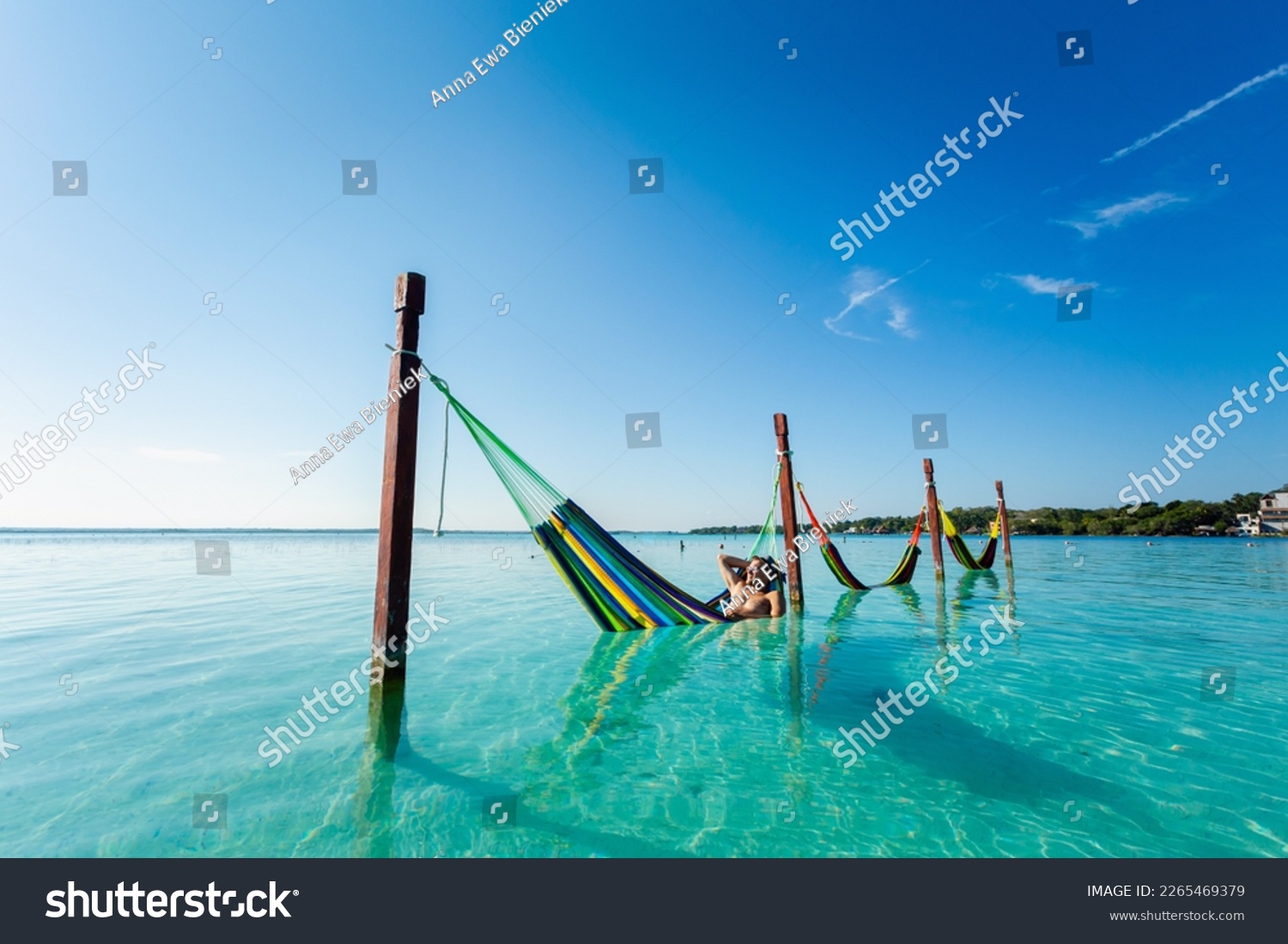 Handsome male tourist relaxing in a hammock in Laguna Bacalar in Mexico during kayak trip. #2265469379