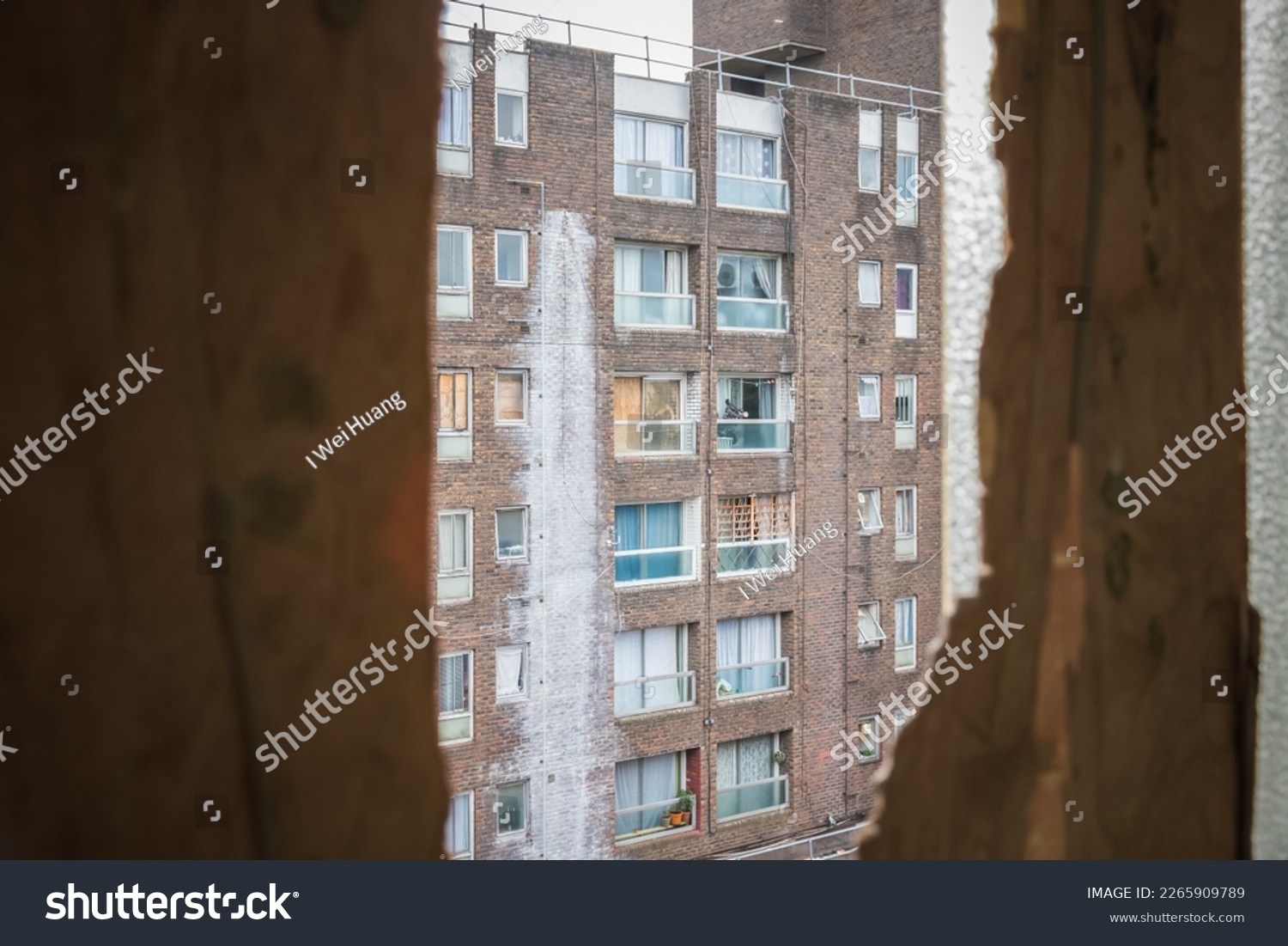 An old council block seen through a broken window in Grahame Park housing estate in London #2265909789