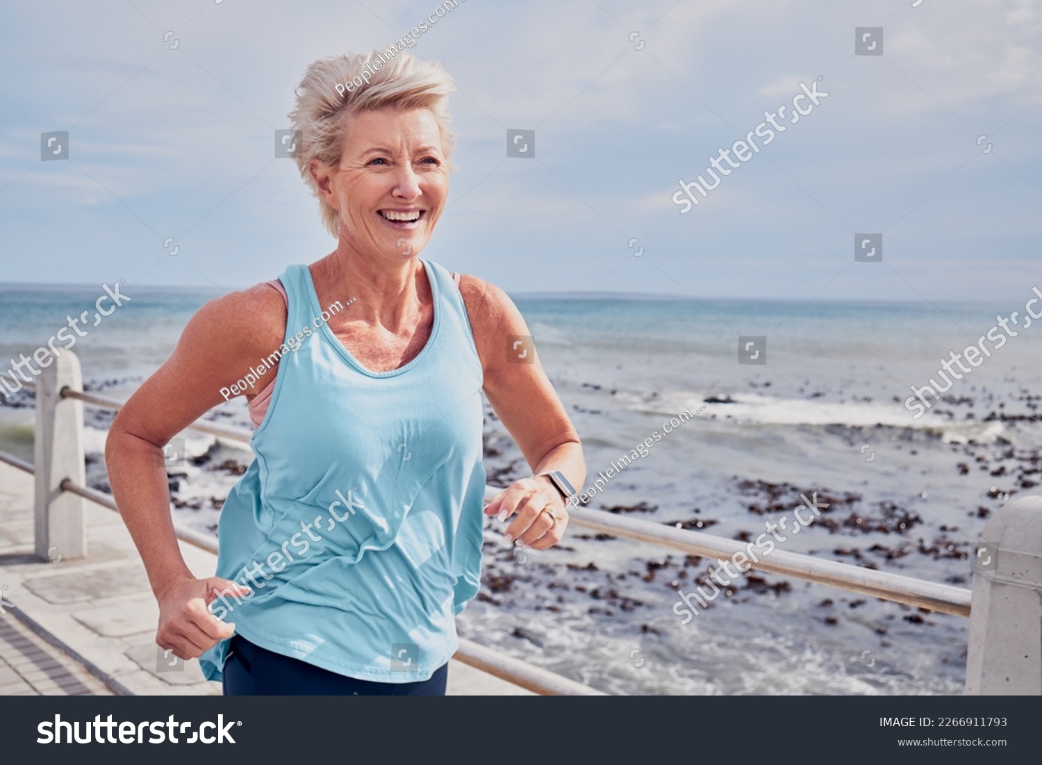 Senior woman, fitness and running at beach promenade, sky mockup and energy of health, wellness and workout. Elderly female, exercise and runner at ocean for happy sports, cardio training or marathon #2266911793