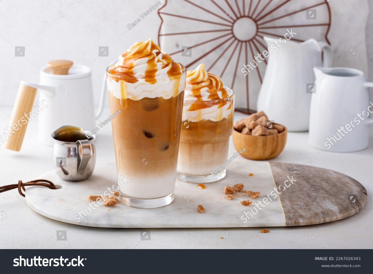 Iced caramel latte in a tall glass with drips of caramel sauce, fancy coffee drink #2267026343