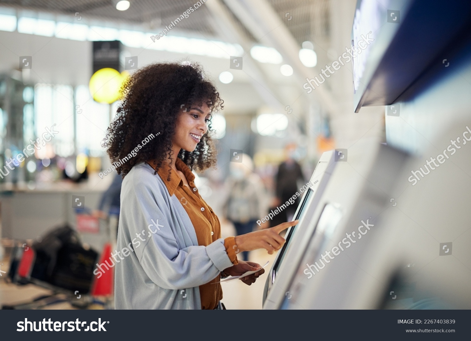 Black woman, airport and smile by self service station for ticket, registration or boarding pass. Happy African female traveler by kiosk machine for travel application, document or booking flight #2267403839