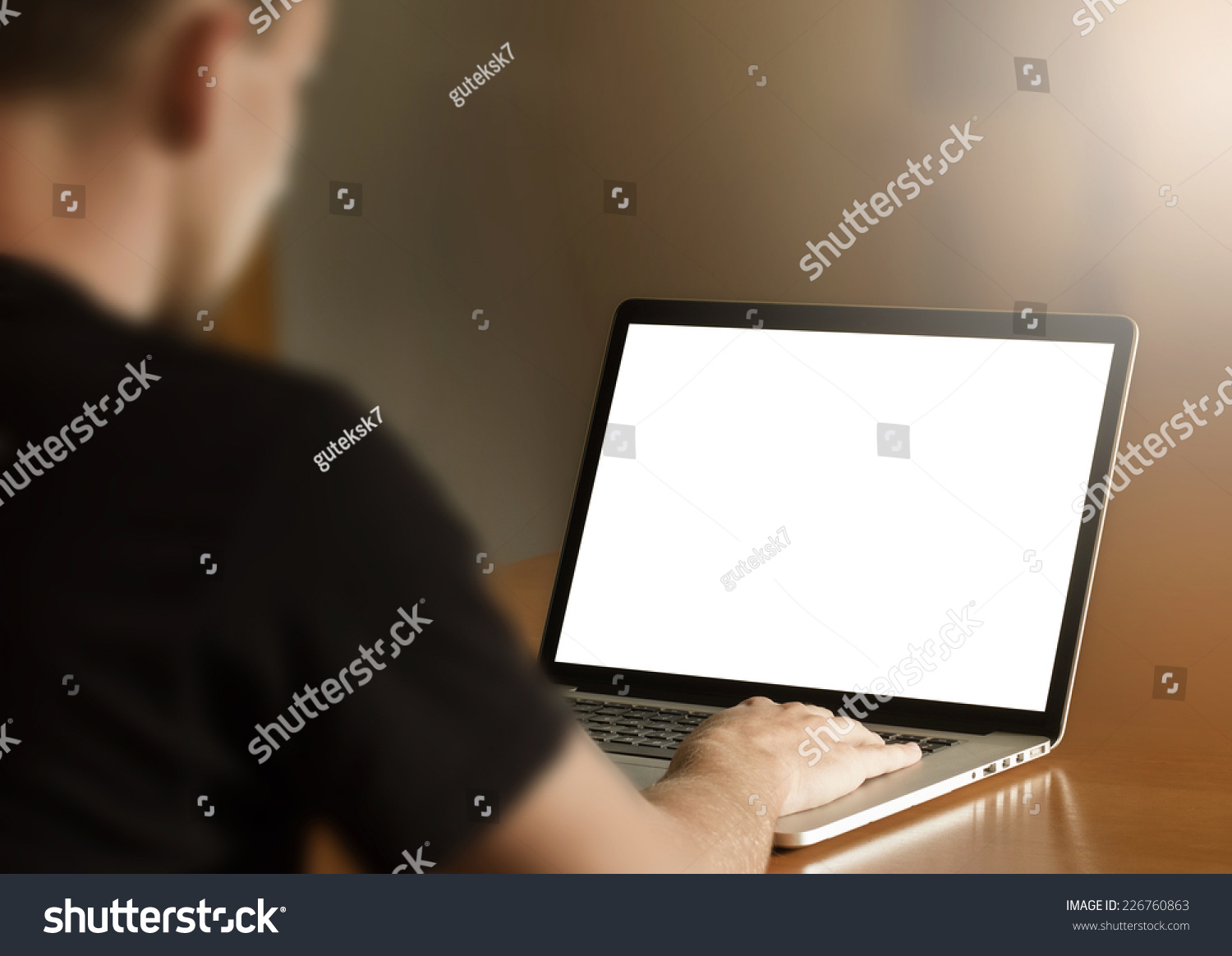 Man using notebook with blank screen in living room. third person view. #226760863