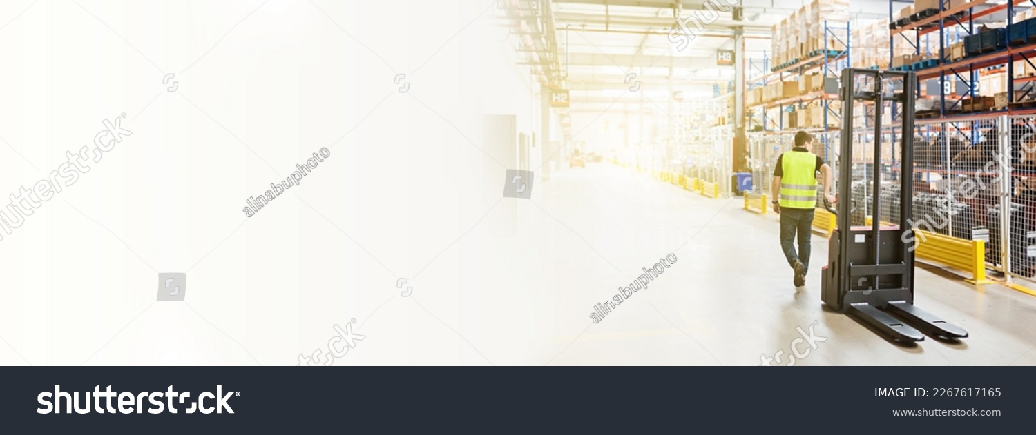 Storehouse employee in uniform working on forklift in modern automatic warehouse. Boxes are on the shelves of the warehouse. Warehousing, machinery concept. Logistics in stock. #2267617165