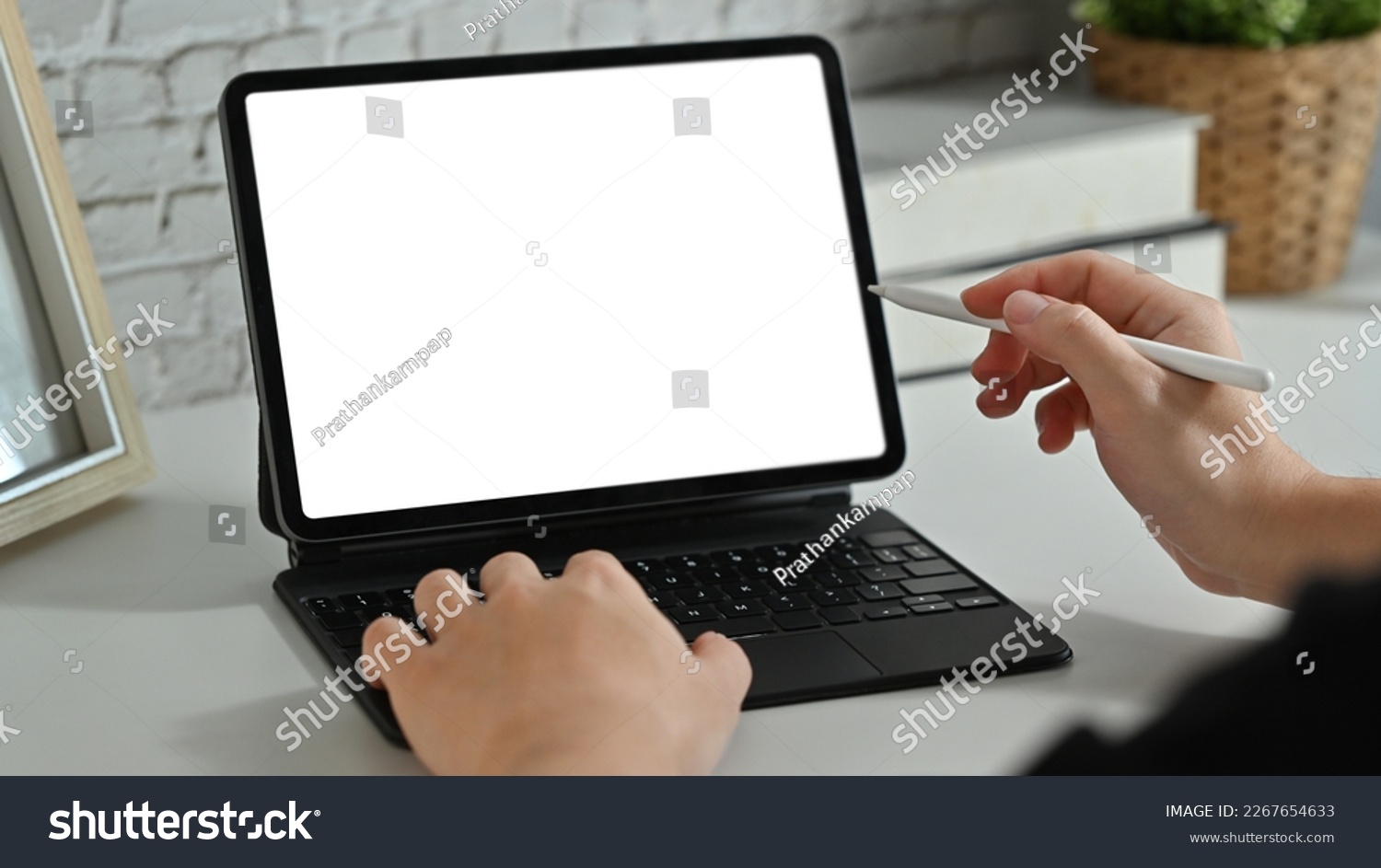 Creative man hand holding stylus pen and pointing on digital tablet screen. Cropped shot #2267654633