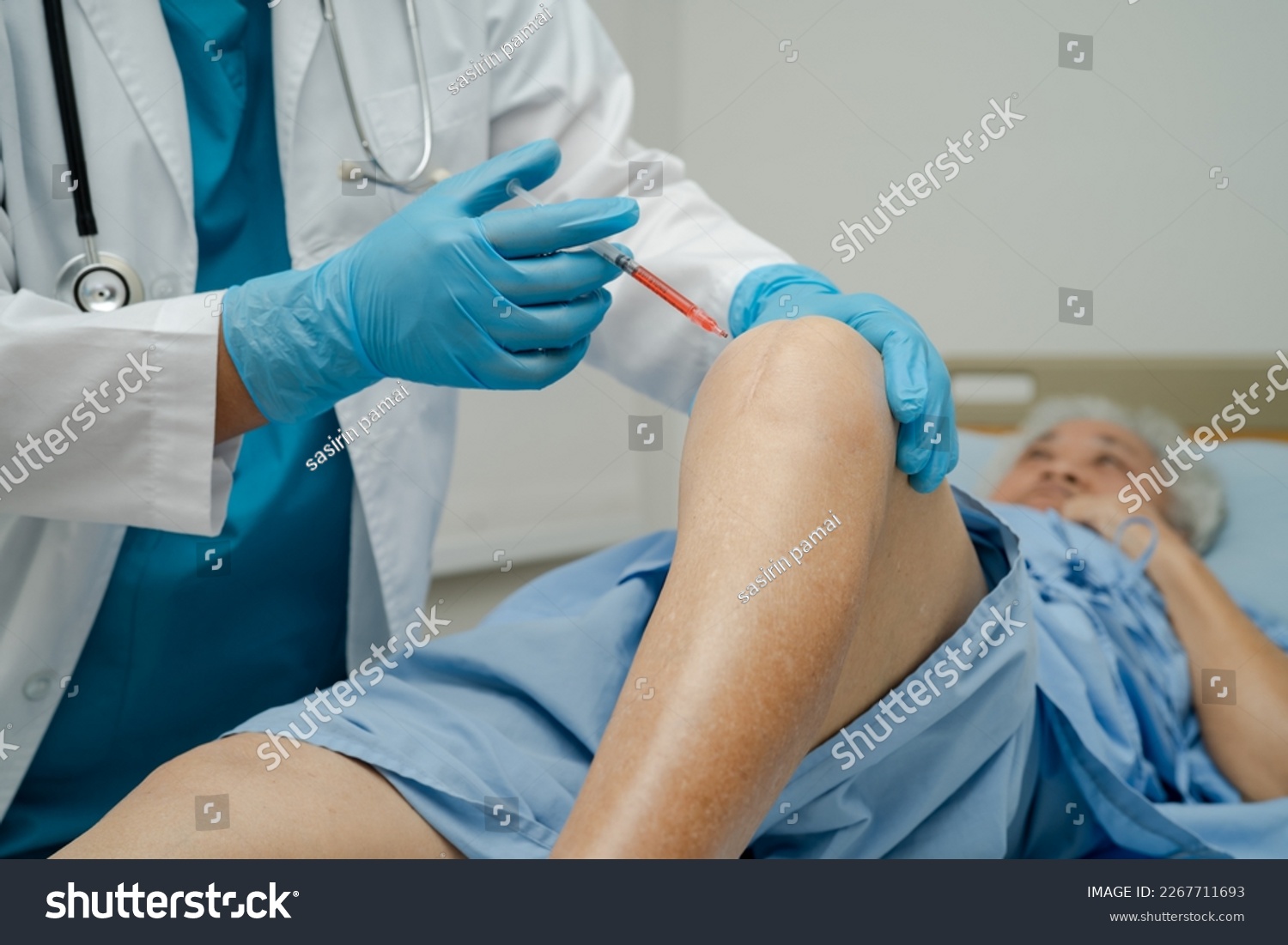 Asian doctor inject Hyaluronic acid platelet rich plasma into the knee of senior woman to walk without pain. #2267711693