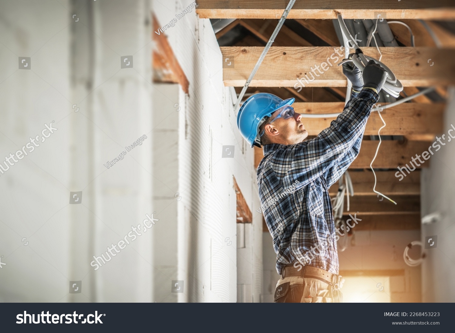 Professional Caucasian Electrician Working on Electrical Wiring System Installation in New Residential House Ceiling. #2268453223