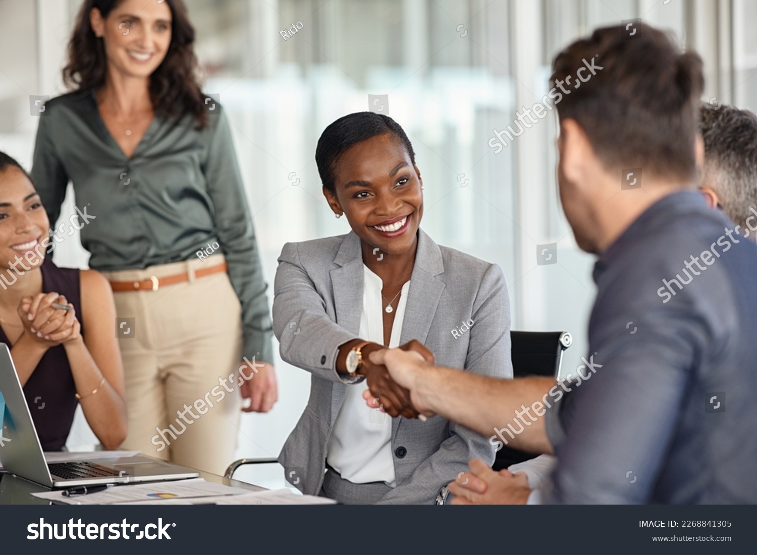 Happy black businesswoman and businessman shaking hands at meeting. Professional business executive leaders making handshake agreement. Happy business man closing deal at negotiations. #2268841305