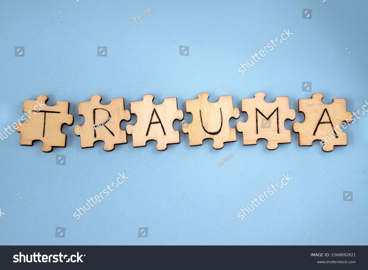 The word TRAUMA wooden written on the puzzles on a blue background #2268892821