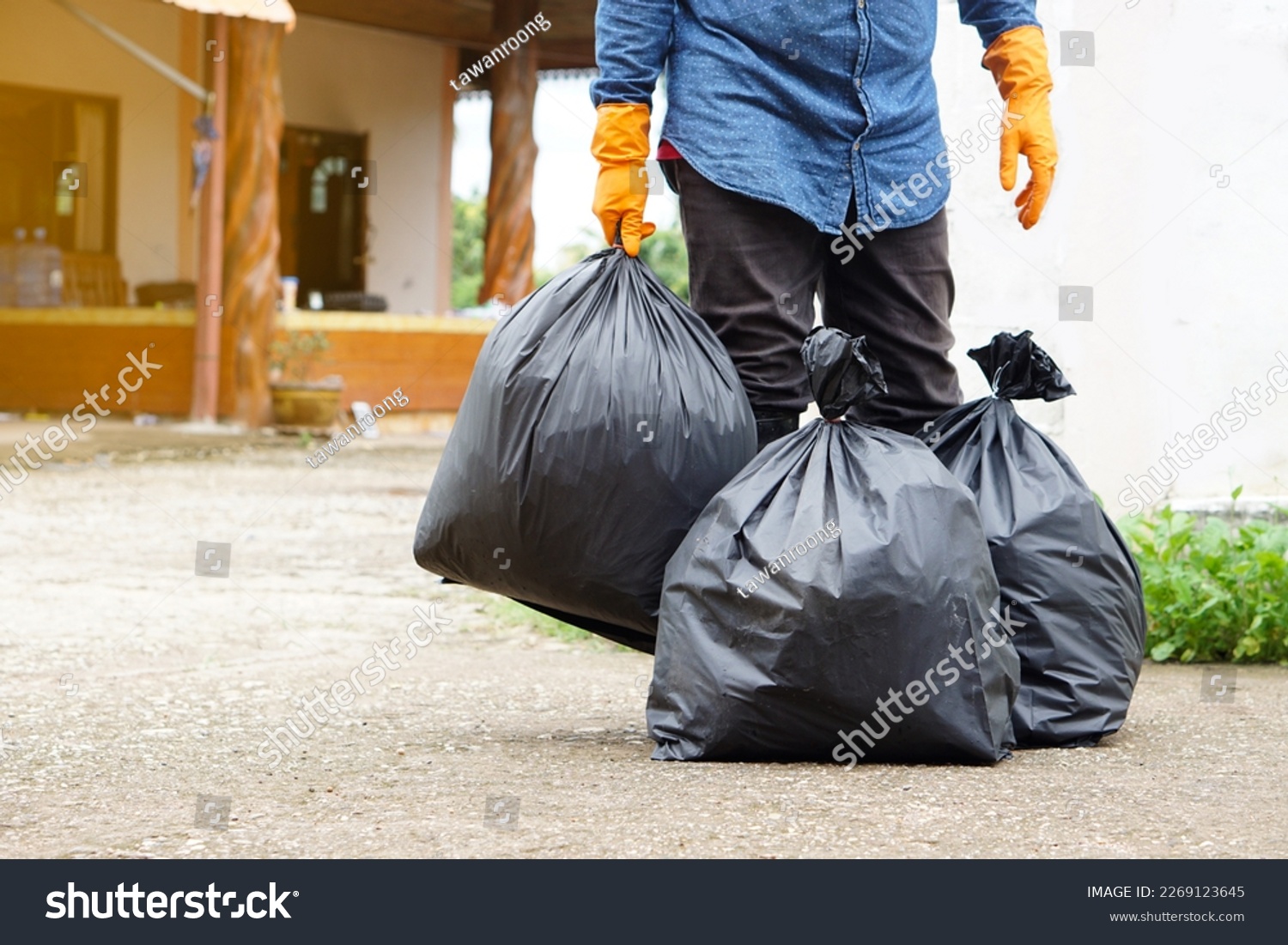 Closeup man holds black plastic bag that contains garbage inside. Concept , Waste management. Environment problems. Daily chores. Throw away rubbish .                         #2269123645