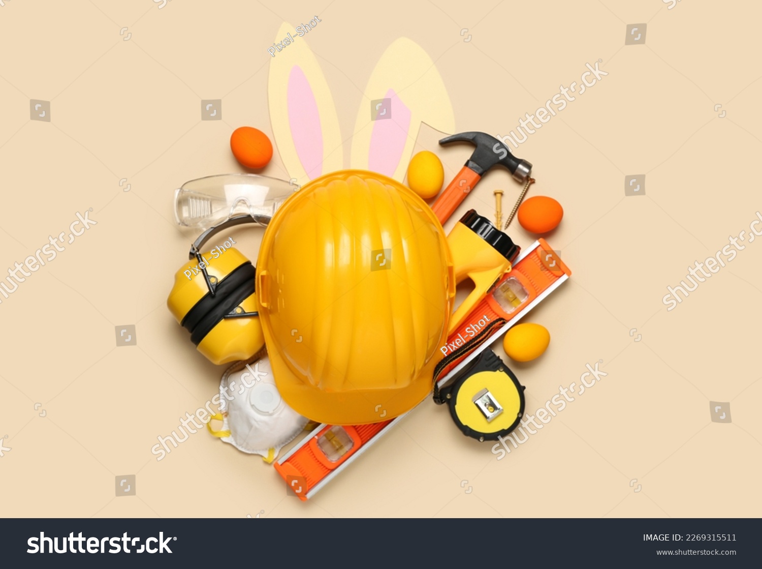 Builder's equipment with bunny ears and Easter eggs on beige background #2269315511