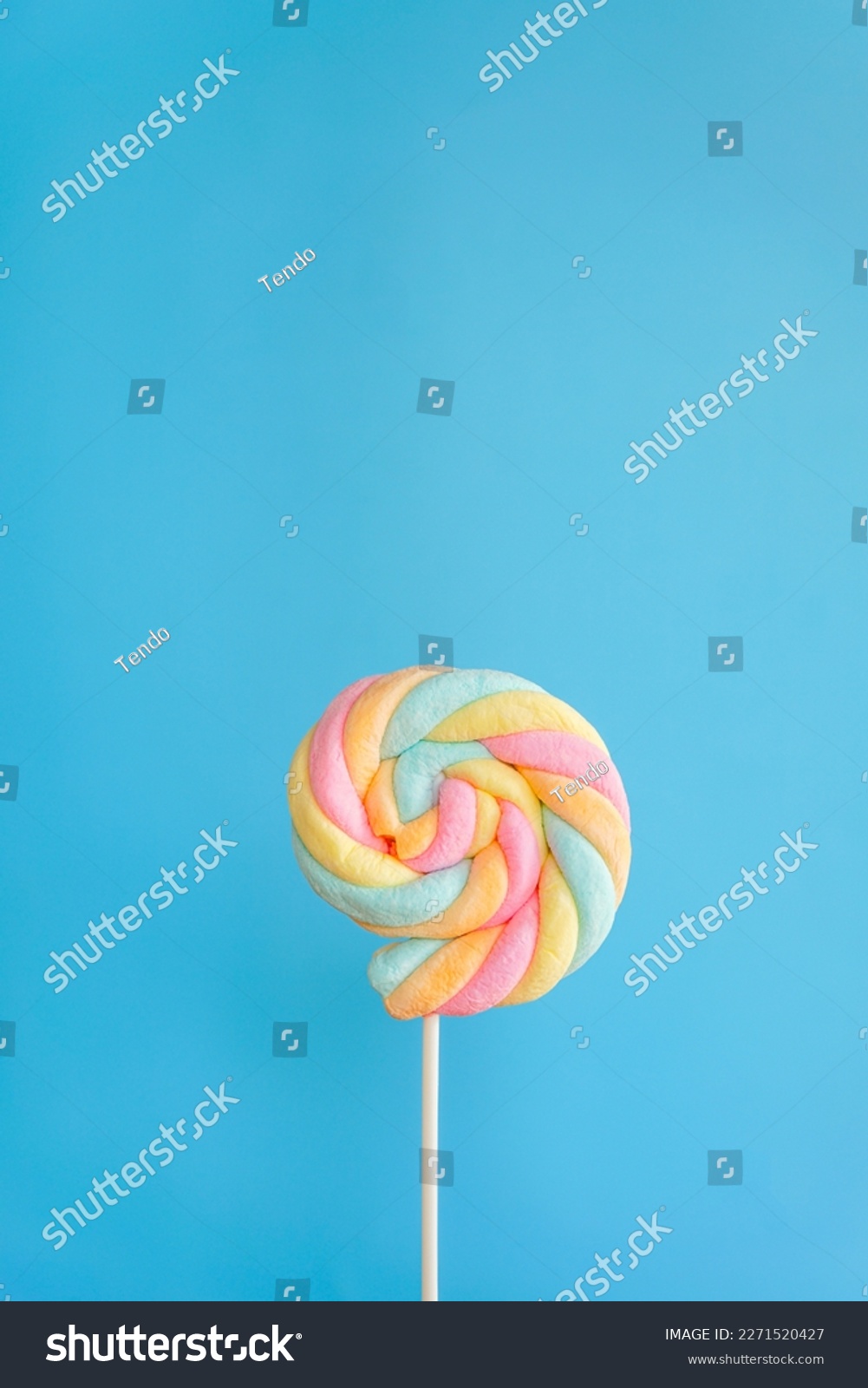 Rainbow twist roll marshmallow like lollipop on blue background  #2271520427