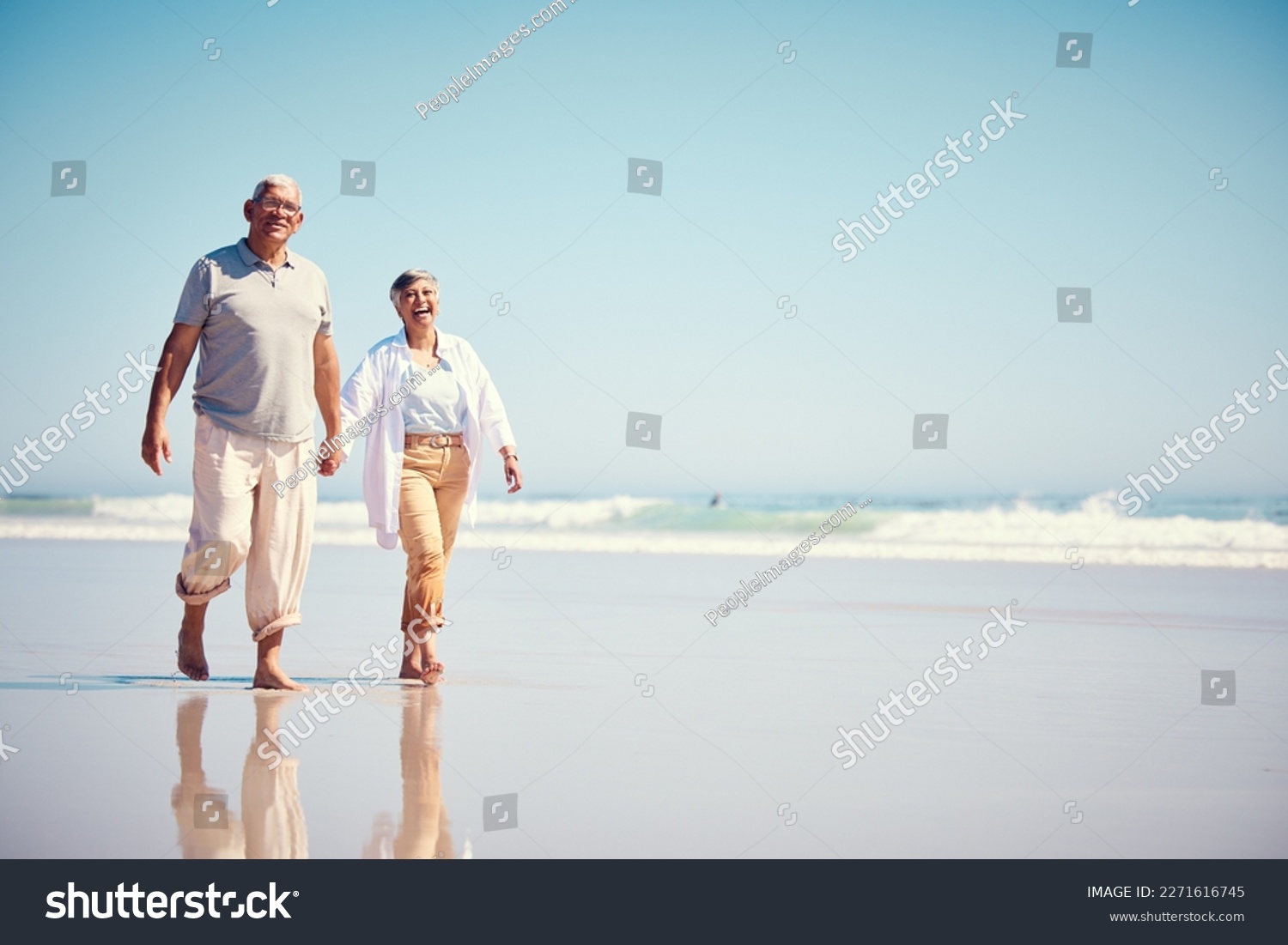 Holding hands, summer and an old couple walking on the beach with a blue sky mockup background. Love, romance or mock up with a senior man and woman taking a walk on the sand by the ocean or sea #2271616745