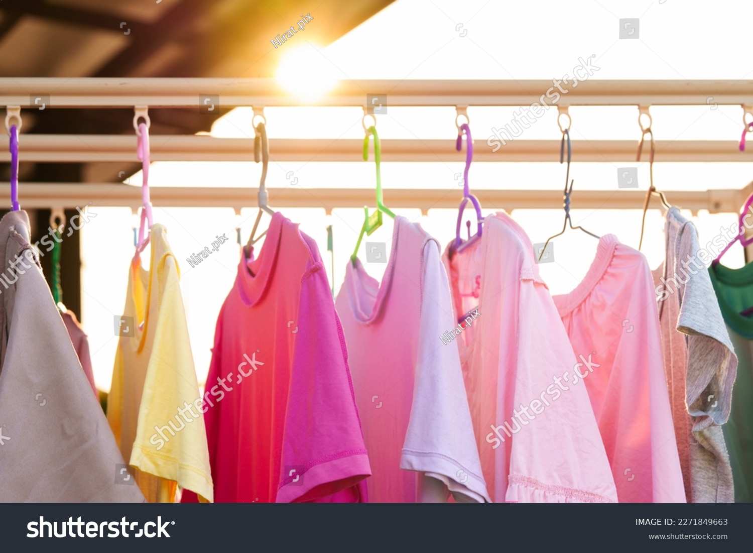 Hanging to dry Up Washing Colorful clothes on a laundry line and sun shining #2271849663