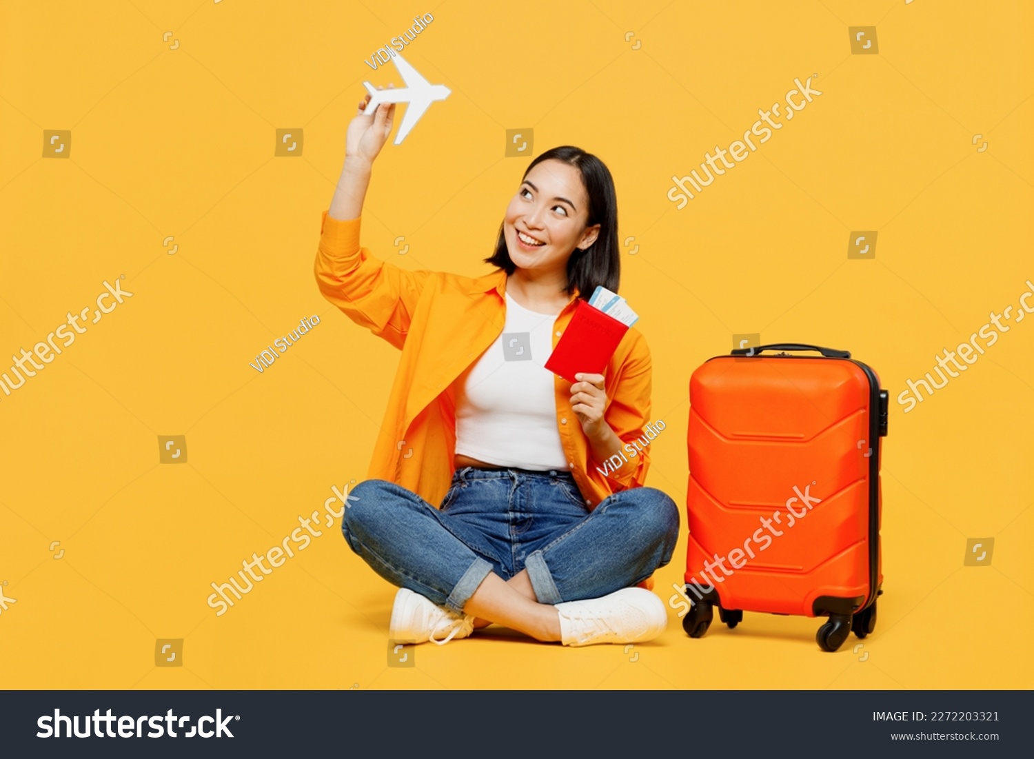 Young woman wear summer casual clothes hold passport ticket airplane mockup isolated on plain yellow background. Tourist travel abroad in free spare time rest getaway. Air flight trip journey concept #2272203321