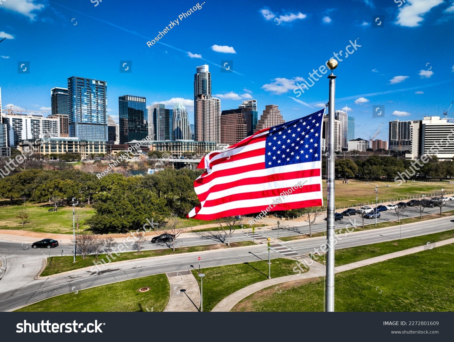American Flag on perfect flag pole flying patriotic flag in front of the Austin Texas USA Skyline Cityscape over a capital city #2272801609