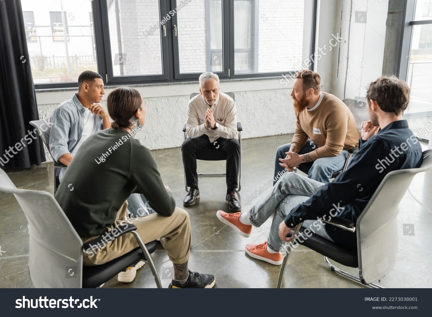 Multiethnic people with alcohol addiction sitting in circle in rehab center #2273038001