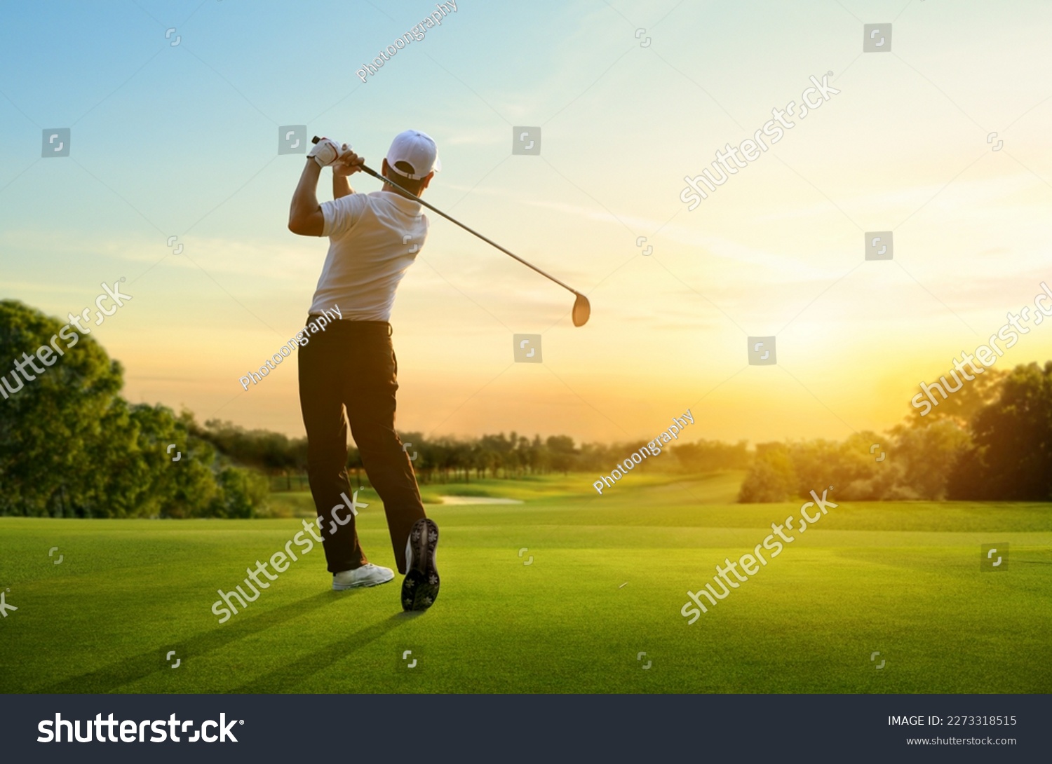 Golfer hit sweeping driver after hitting golf ball down the fairway with sunrise background. #2273318515