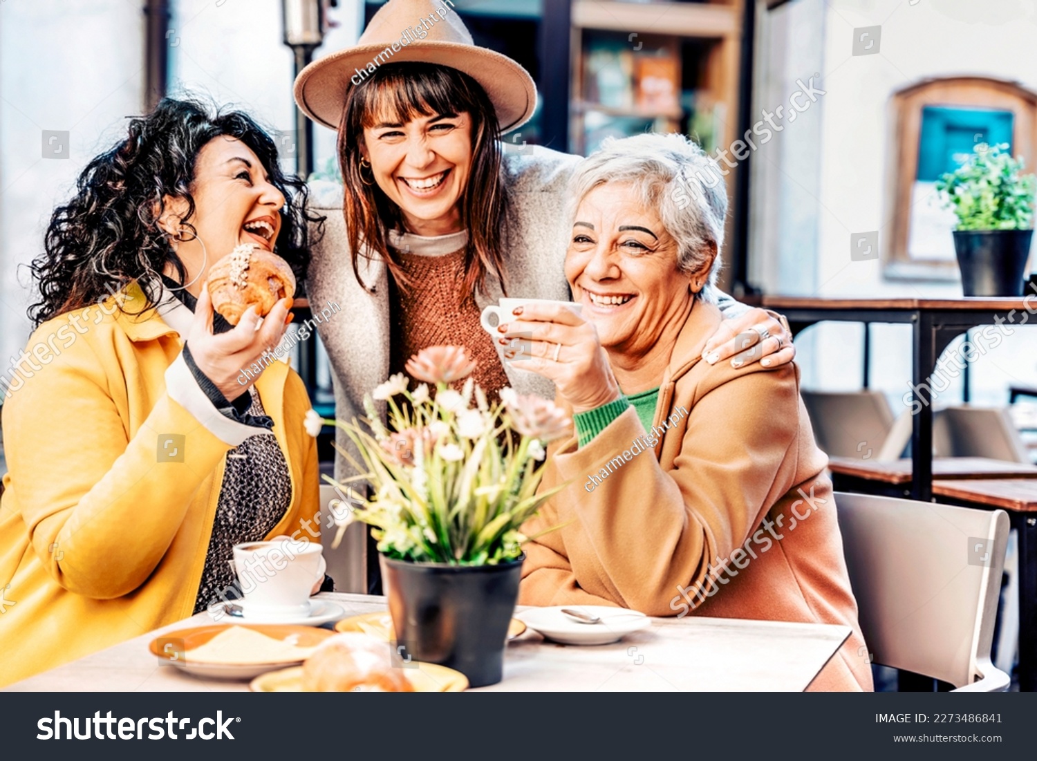 Group of happy elderly women having fun during breakfast in a cafeteria - Three retired female friends drinking coffee and cappuccino and eating croissant at bar - Mature female life style concept #2273486841