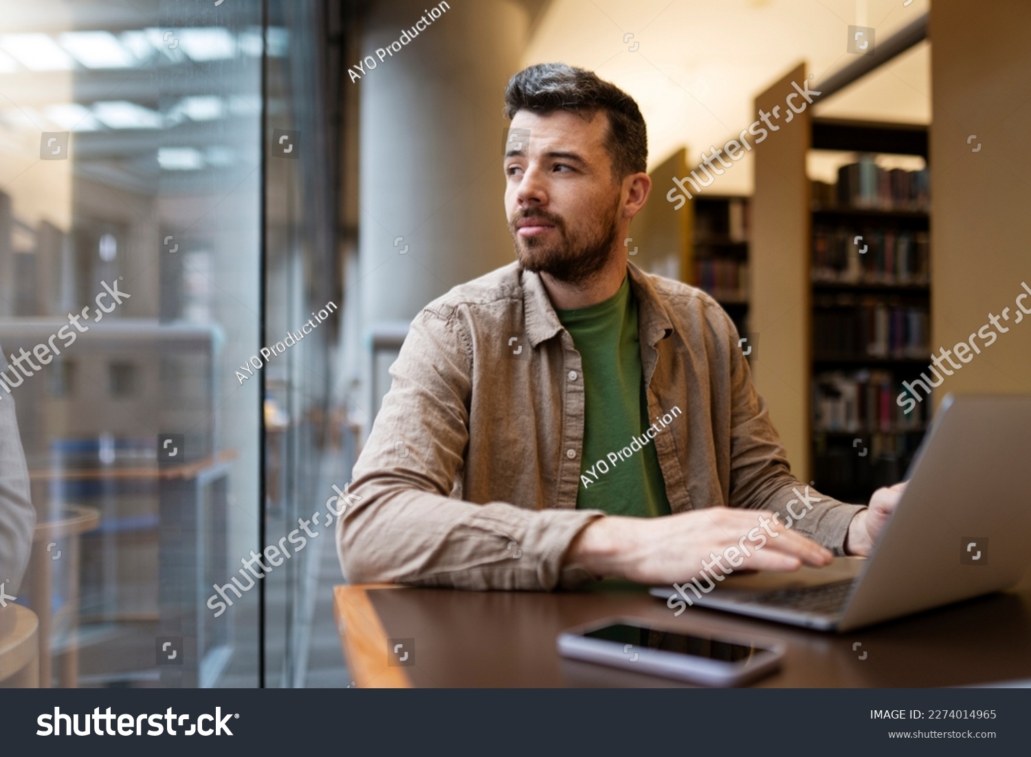 Portrait of attractive businessman, using laptop, hispanic man working online. Middle aged hipster guy working in modern office, looking away. Successful programmer sitting at desk  #2274014965