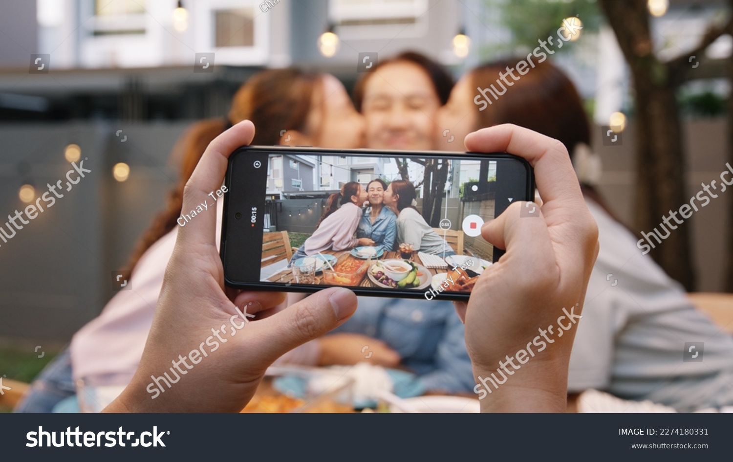 Young adult asia people hug cuddle kiss love care for mom taking photo selfie video on mobile phone camera at home picnic dining fun night party dine table. Relax older mum smile enjoy warm time meal. #2274180331