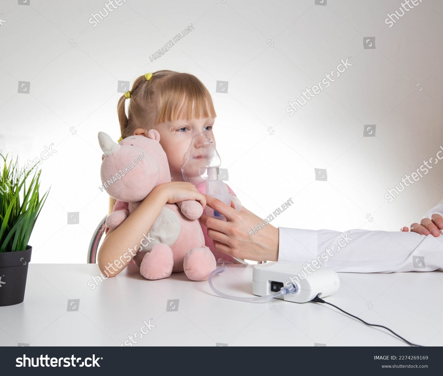 Beautiful little girl breathing into an inhaler for asthma and pneumonia at home. Treatment of diseases of the upper respiratory tract in children. Copy space for text, laryngitis #2274269169
