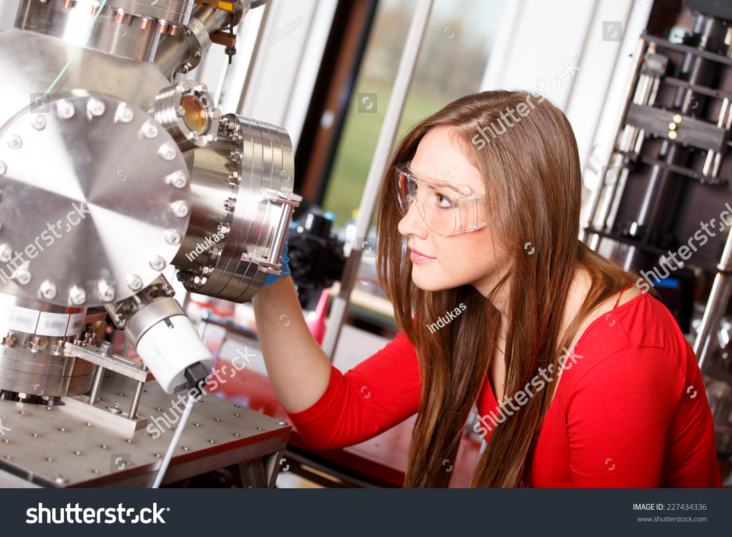 Female scientist looking to the laser deposition chamber #227434336