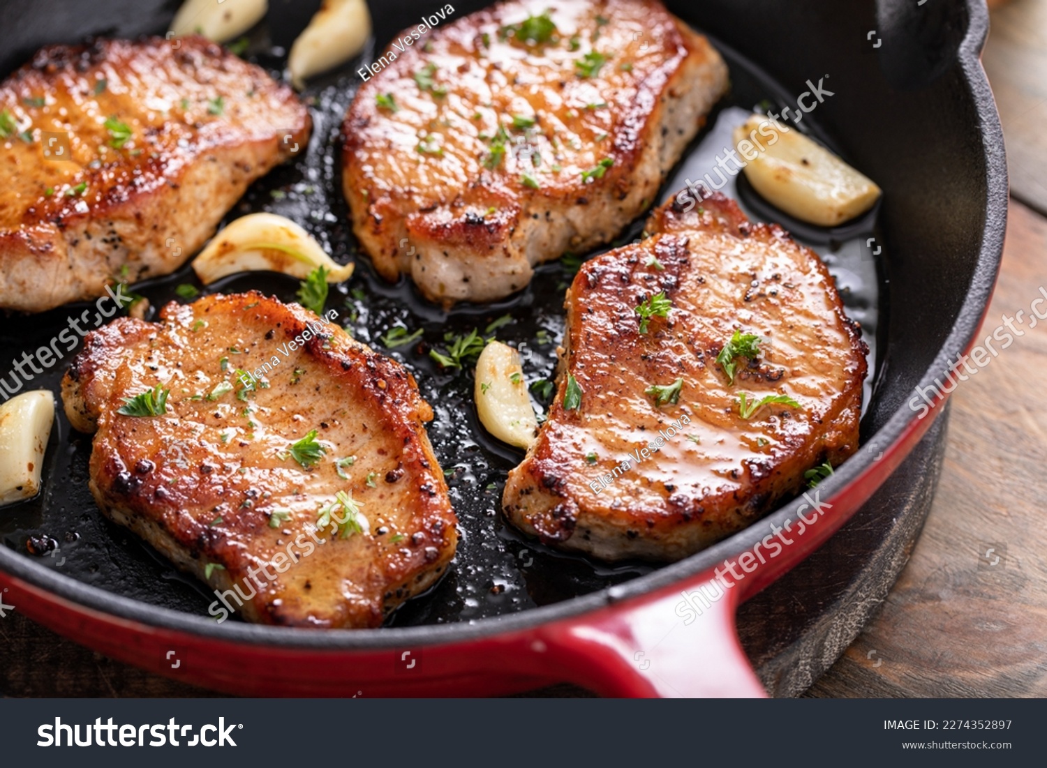 Pork chops cooked with garlic in a cast iron pan #2274352897