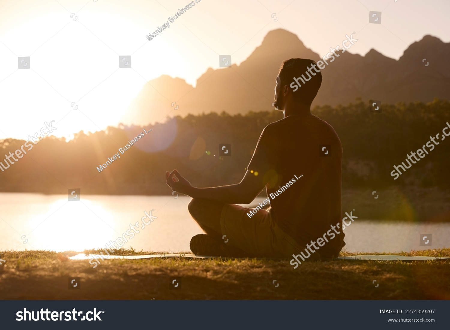 Man Meditating Doing Yoga By Lake And Mountains At Sunset #2274359207
