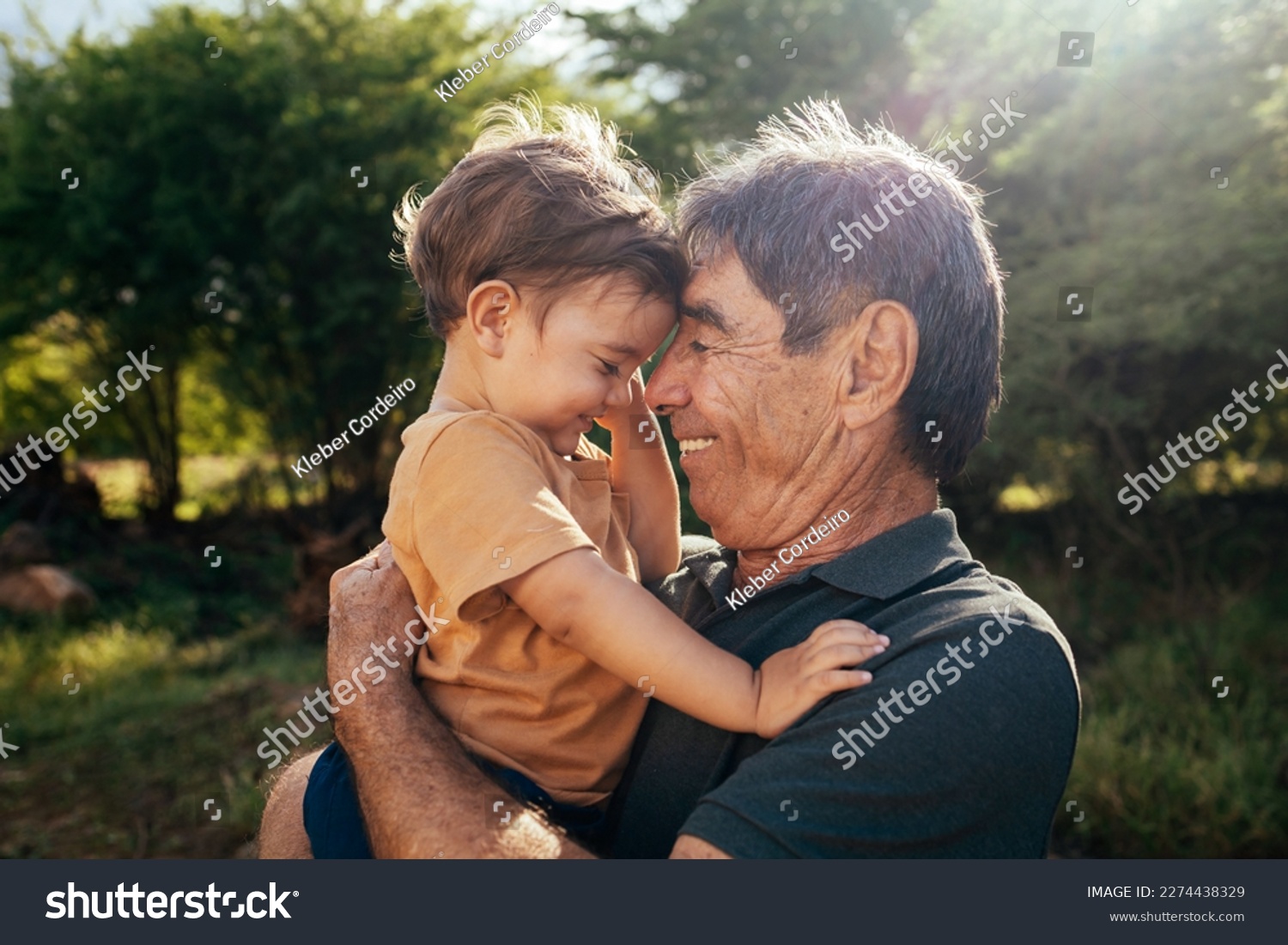 Playful grandfather spending time with his grandson in park on sunny day #2274438329