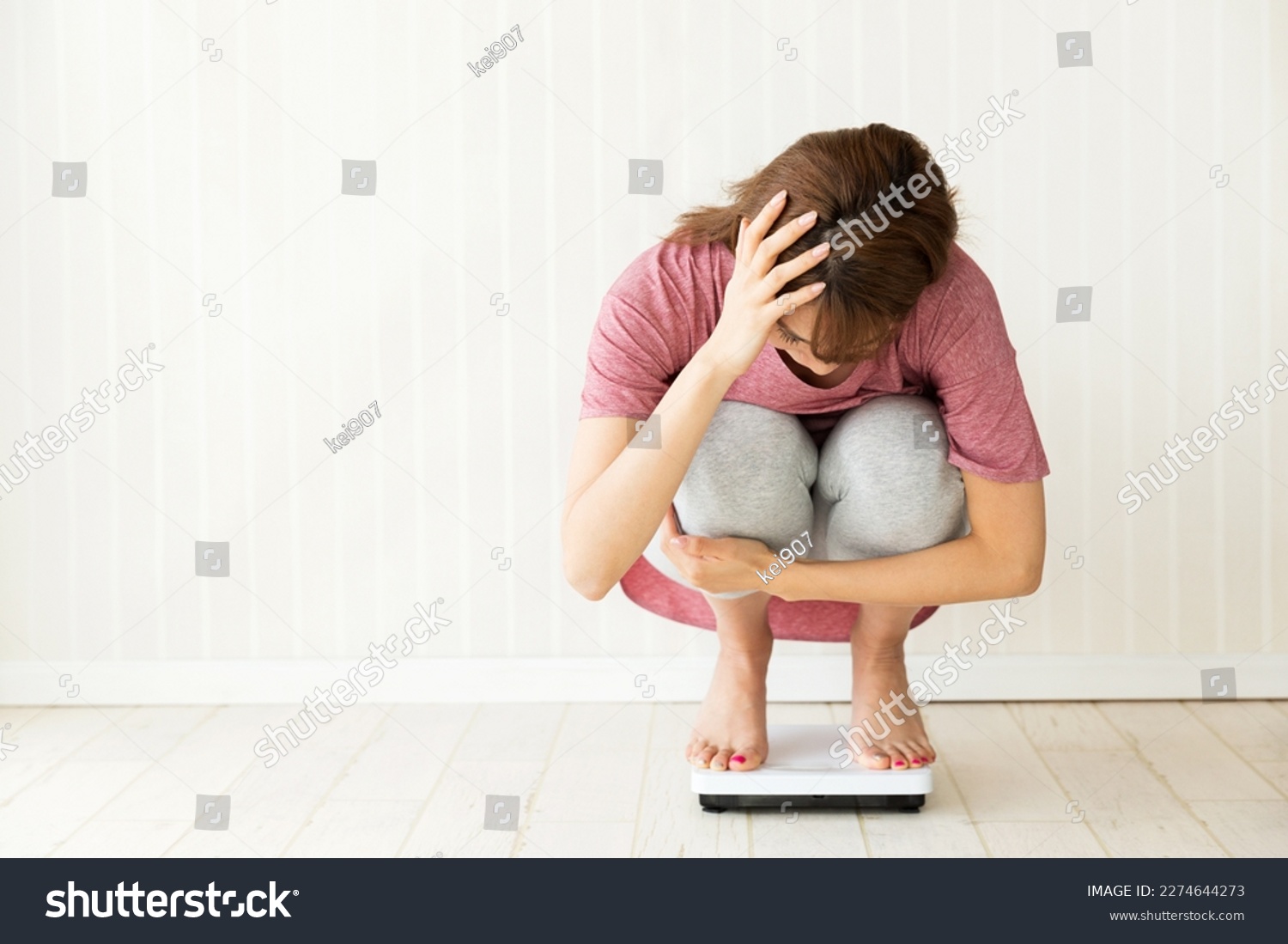 Young woman riding a weight scale. #2274644273