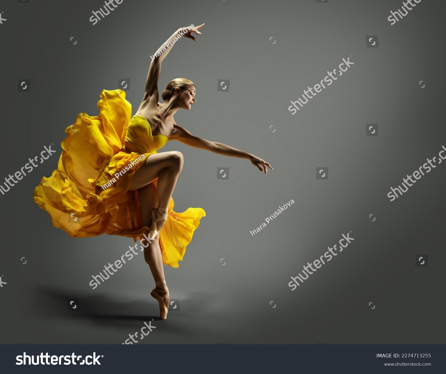 Ballerina in Yellow Chiffon Dress dancing over Gray Background. Ballet Dancer jumping in Air in Silk Gown. Modern Dance Graceful Woman performing in flying Skirt #2274713255