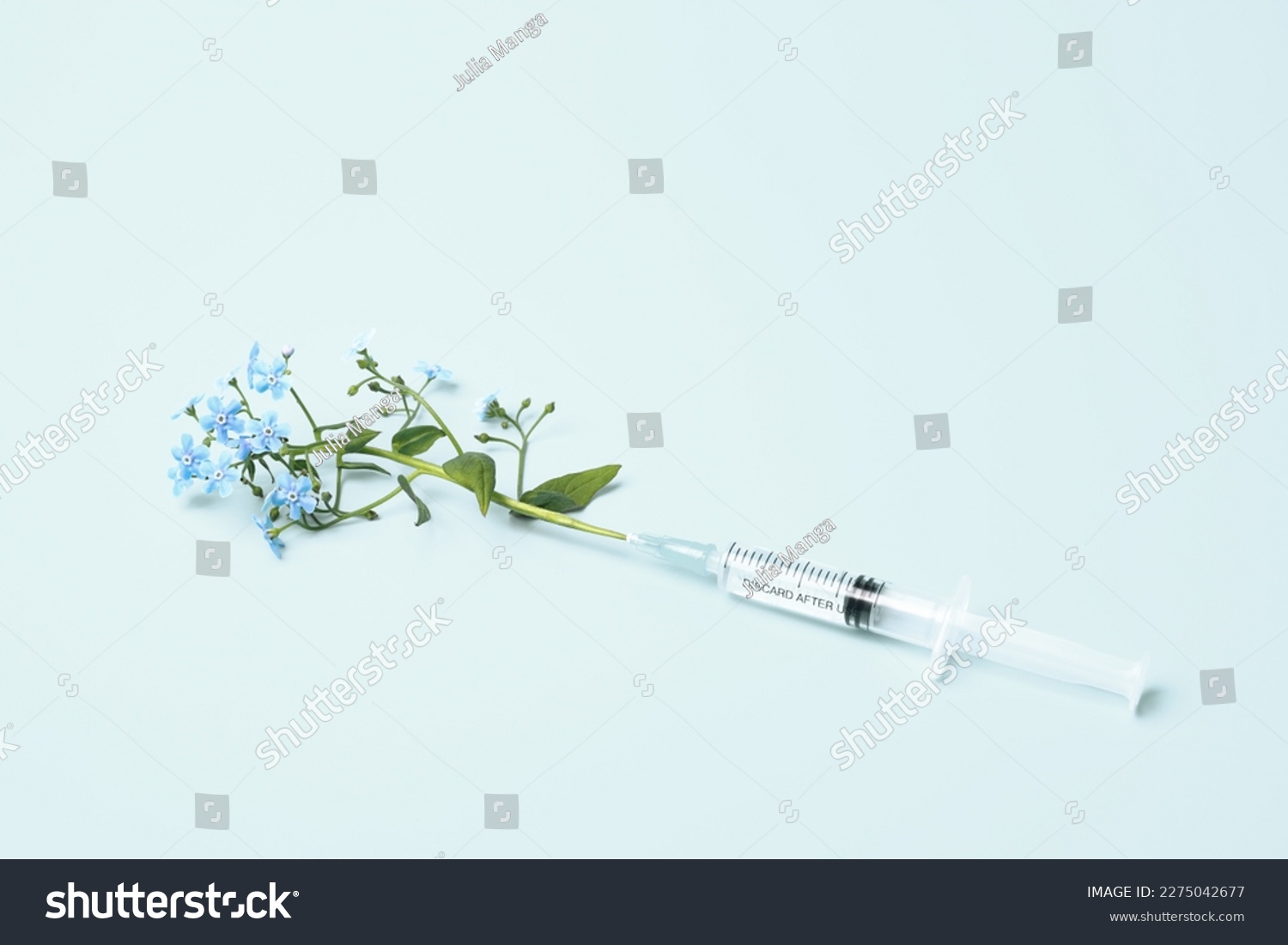 Injection syringe and flowers on blue background. Beauty Injections, vaccine creative concept. Healthcare and medical cosmetology. #2275042677