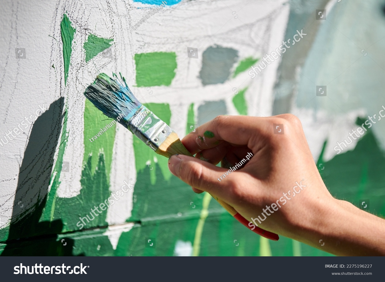 Girl artist hand holds paint brush and draws green nature landscape on white canvas at outdoor art painting festival, paintings art picture process. Woman artist paints atmospheric surreal picture #2275196227