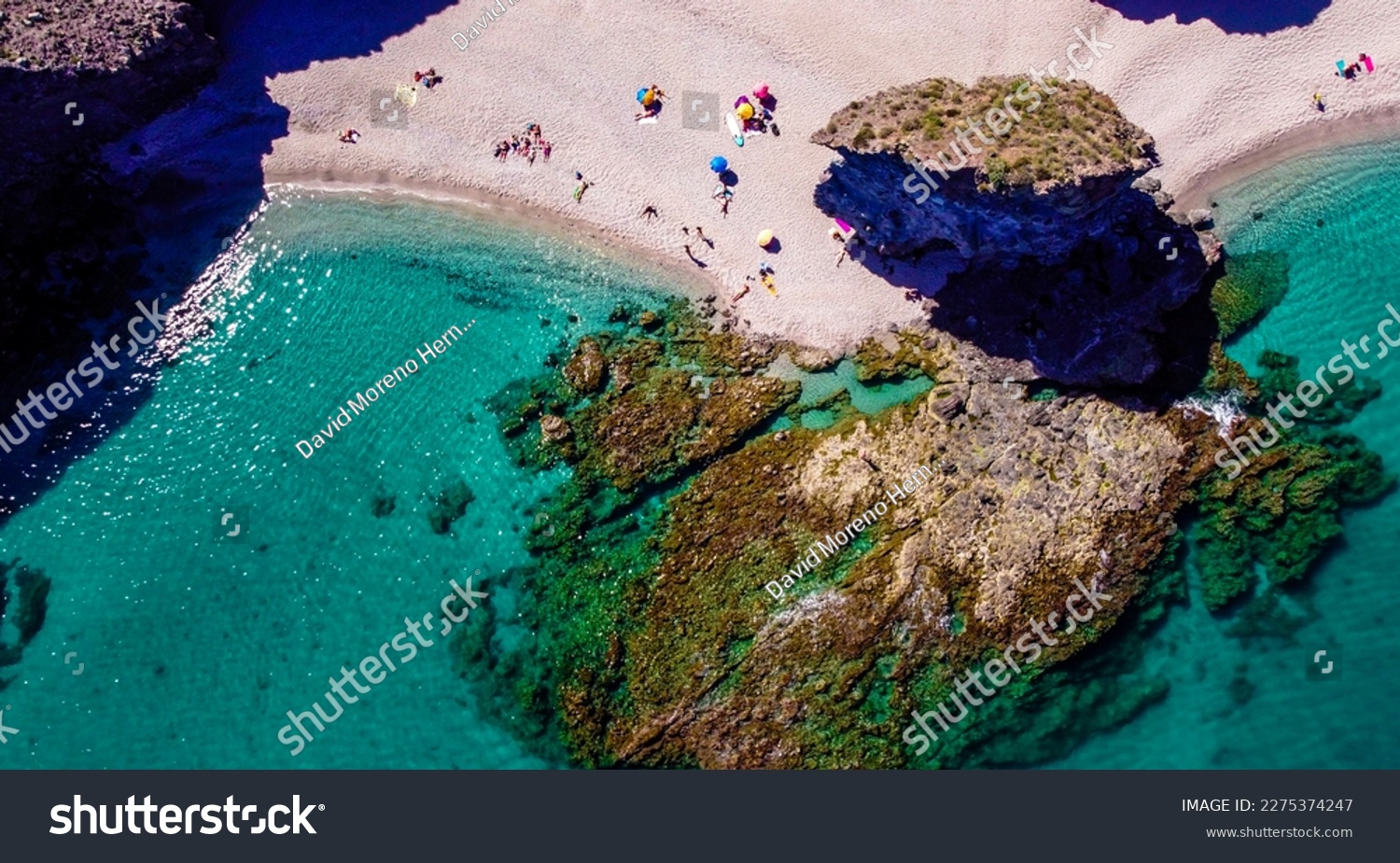 Seashore, coastline, scenic view of people at unspoiled beach in Almeria, called Playa de los Muertos, in English The beach of Deads due to the strong currents that cause many deaths year after year #2275374247
