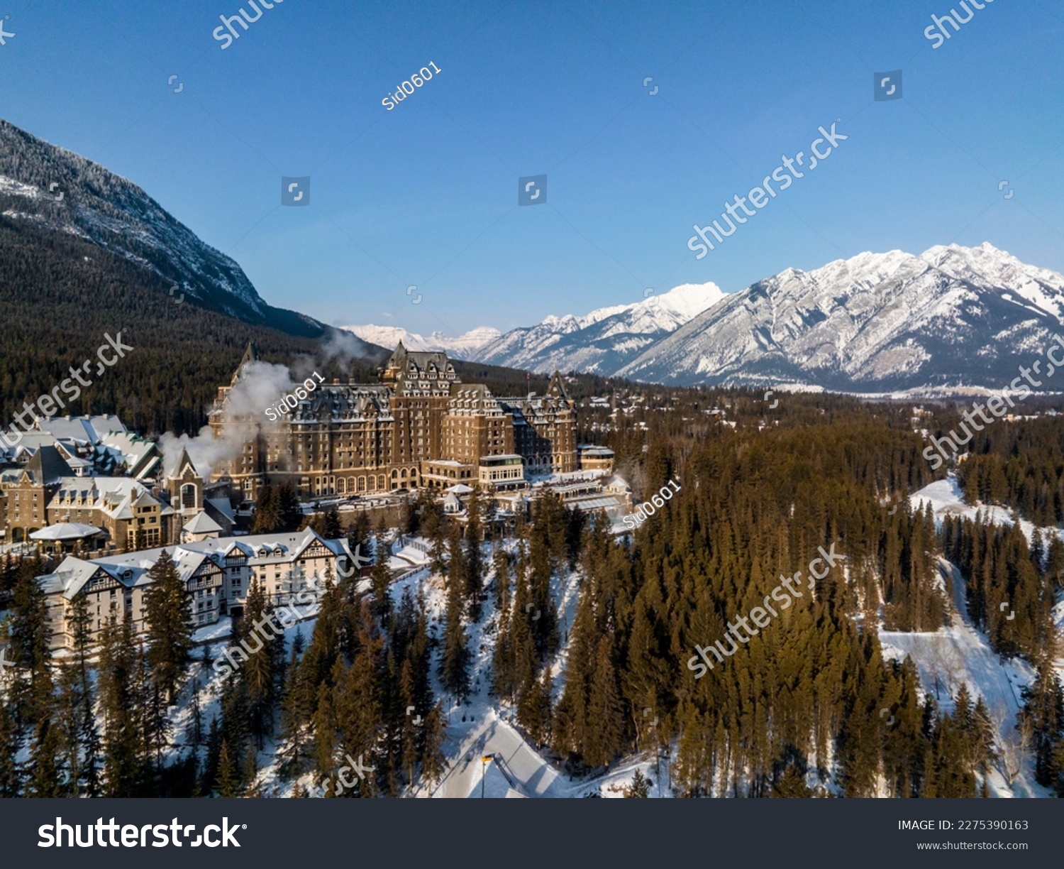  aerial view of Fairmont Banff Springs hotel during winter sunrise in banff with mountains on background #2275390163