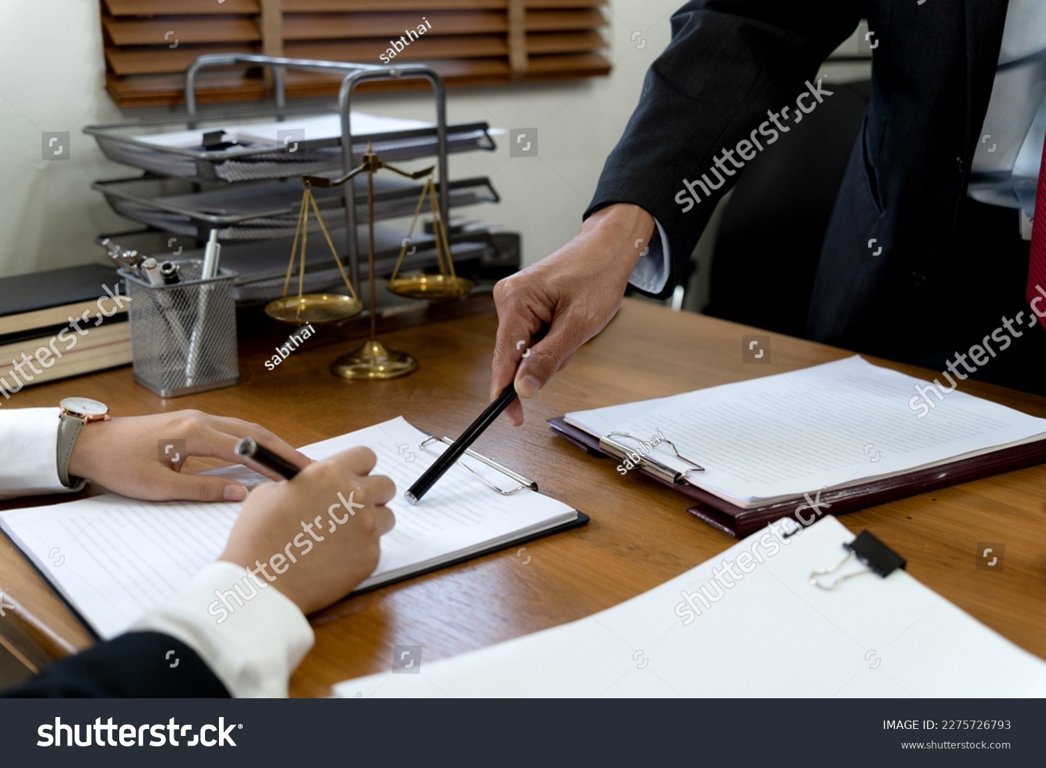 Law firms discussing with pen pointing at documents drafting or amending contracts in law firm office
 #2275726793