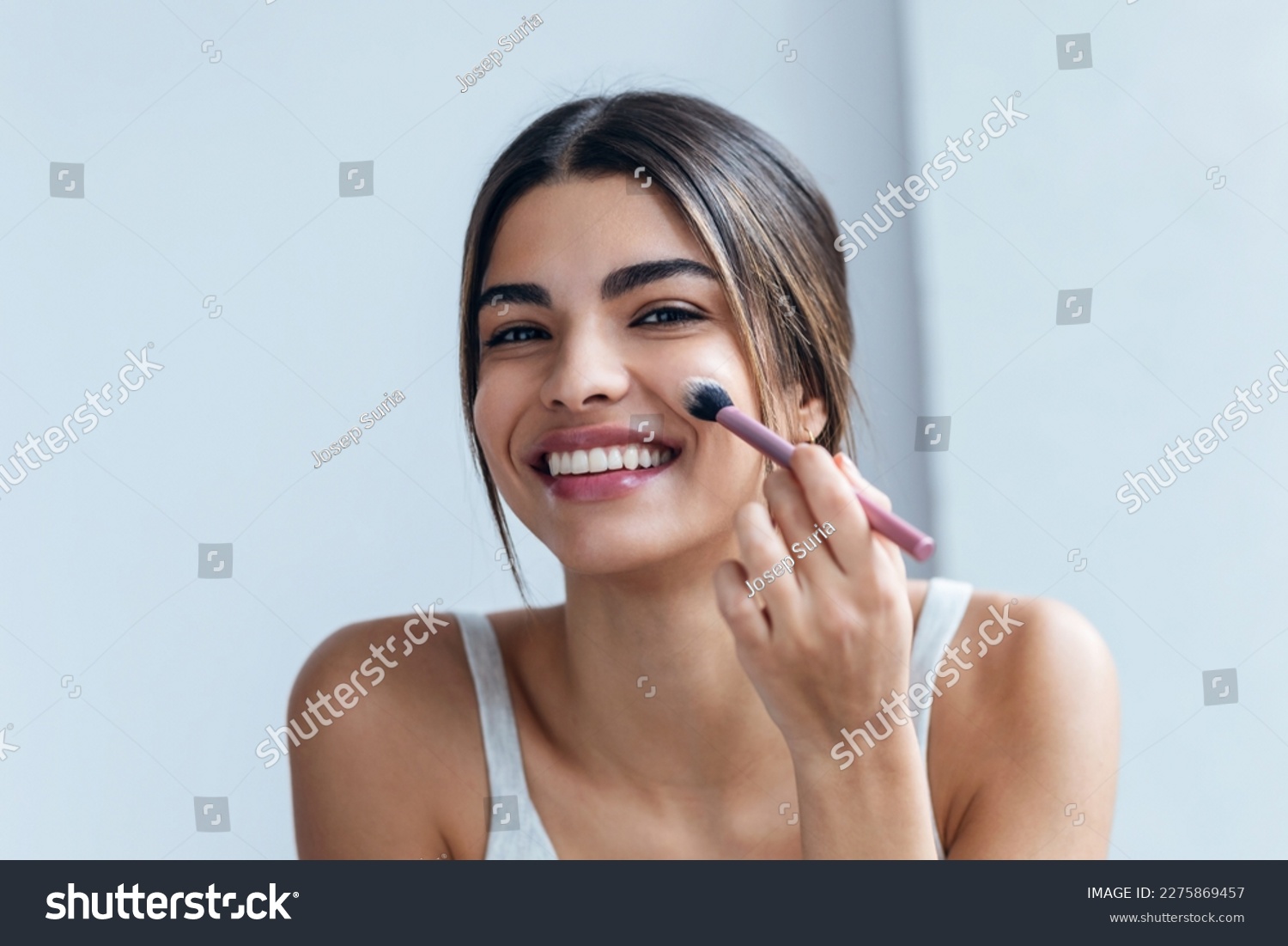 Shot of beautiful young woman making make-up near mirror in the bathroom. #2275869457