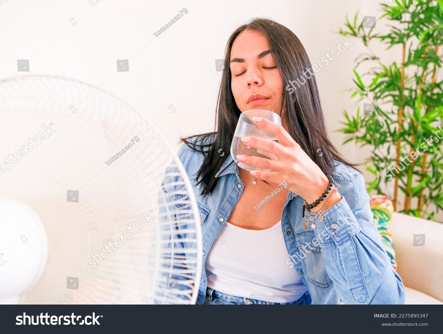 Woman suffering summer heat trying to stay cool and comfortable during heat wave #2275895347