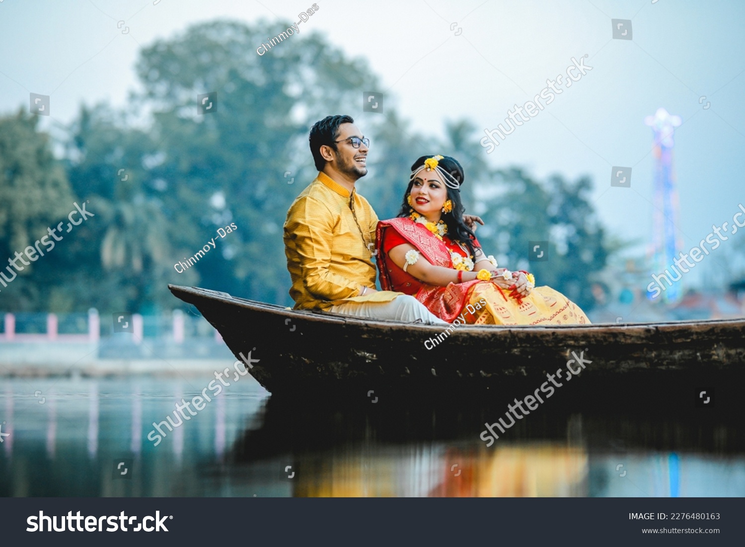 A beautiful happy indian bride and groom in the boat. a  indian bride and groom in traditional wedding dresses. #2276480163