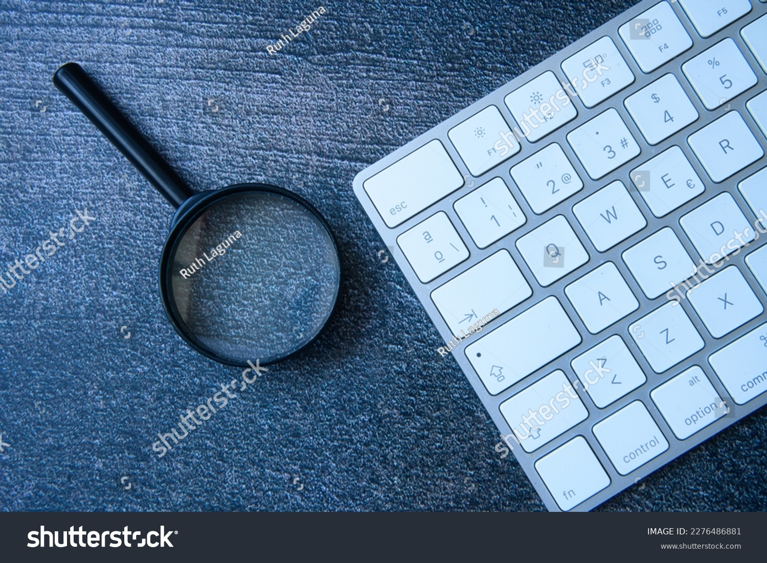 the magnifying glass and keyboard are the perfect combination as a concept in the search of right keywords that will improve your website's search engine ranking. #2276486881