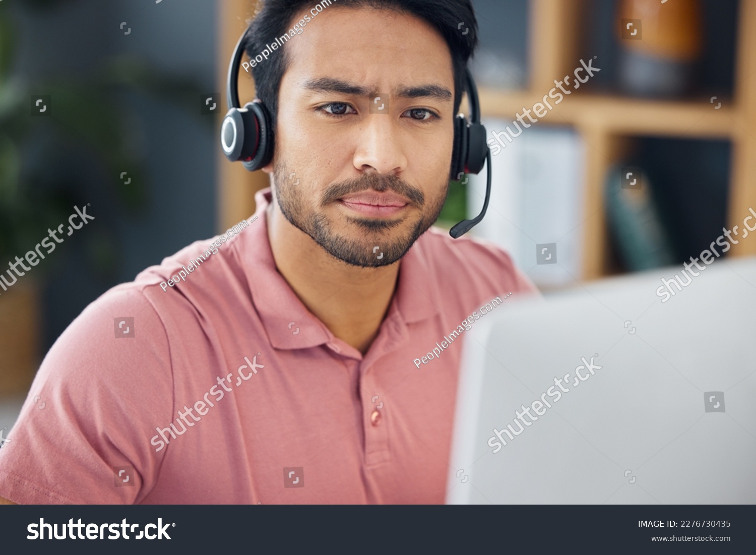 Serious asian man, call center and computer with headphones for customer service, help or support at office. Focused male consultant or agent with headset on PC for telemarketing or online advice #2276730435