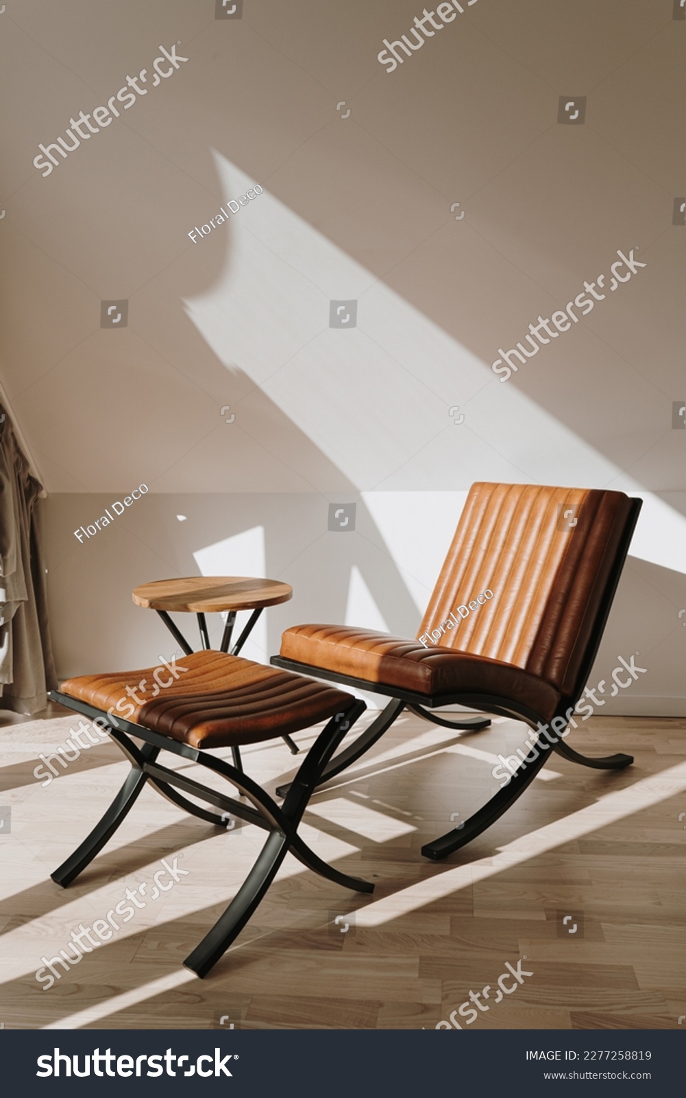 Modern interior decorated with leather lounge armchair. Aesthetic warm sunlight shadows on the wall. Minimalist home interior design concept #2277258819