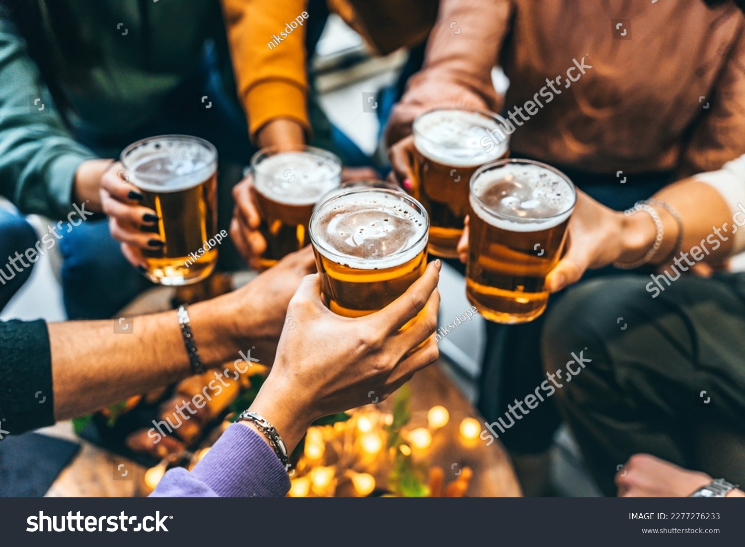 Group of friends drinking and toasting glass of beer at brewery pub restaurant- Happy multiracial people enjoying happy hour with pint sitting at bar table- Youth Food and beverage lifestyle concept
 #2277276233