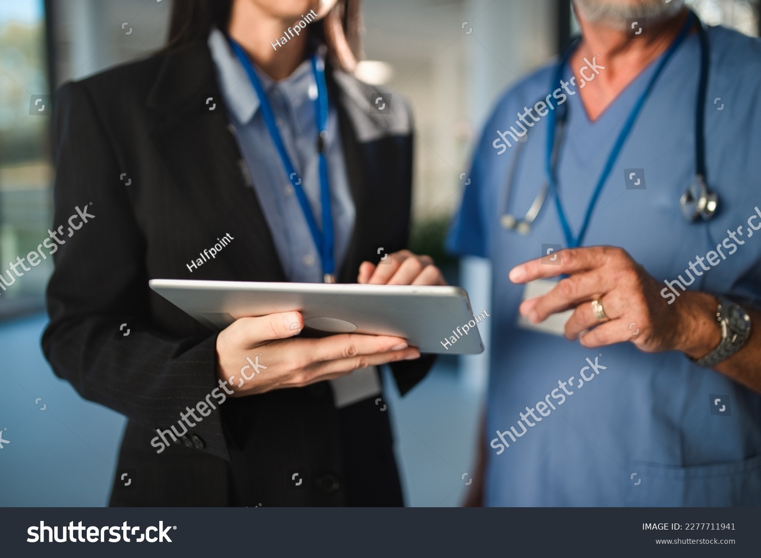 Close-up of young pharmaceutic seller explaining something to doctor in hospital. #2277711941