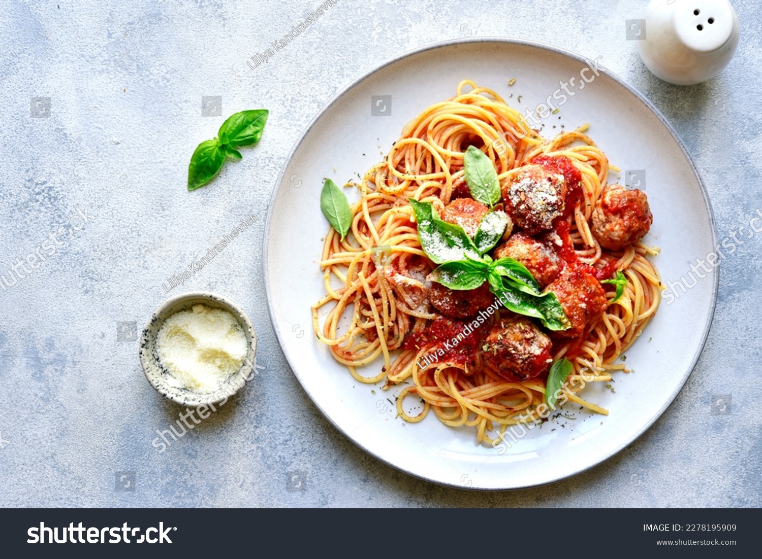 Pasta spaghetti with meat ball in tomato sauce on a plate over light grey slate, stone or concrete background. Top view with copy space. #2278195909
