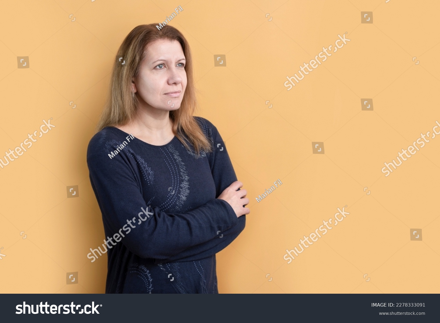 A woman on a yellow background looks up with hope, there are difficulties and problems in her life, but she is not disappointed, she believes and prays, she wants to be a good mother and wife #2278333091